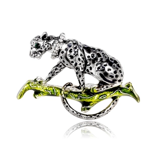 Vintage leopard brooch in silver alloy with black enamel spots on a green branch