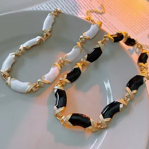 Collier croisé vintage en émail noir et blanc avec chaîne en métal doré élégant