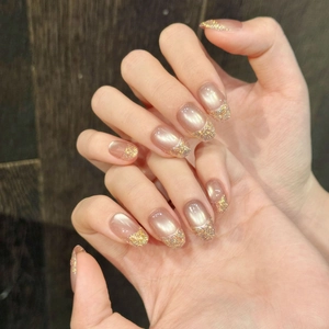 Close-up of champagne gold cat eye press-on nails with glitter gradient and diamond accents
