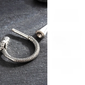 Detailed macro of a steel snake ear gauge with fine scales and screw closure mechanism