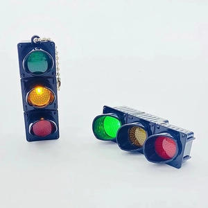 Detail showing glowing LED traffic light keychain with yellow and green signal lights