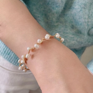 Handmade freshwater pearl gold wire-wrapped bracelet worn on wrist for women