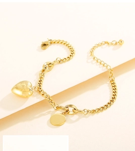 Detail of golden heart bracelet with Blind for Love engraving and round charm