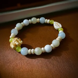 Bracelet en perles pastel avec breloques éléphant et feuille sur cuir marron