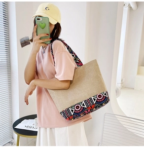 Close-up of ethnic geometric pattern details on the beige canvas tote bag shoulder strap
