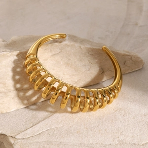 Detailed macro view of 18k gold plated stainless steel bracelet with spiral ribbed texture