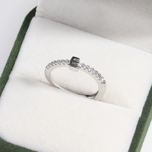 Macro shot of silver crystal ring with square setting in a green velvet jewelry box