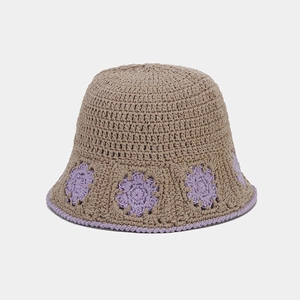 Detail of crochet bucket hat with purple flower patterns and handmade knit texture