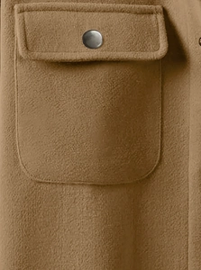 Close-up of brown corduroy work jacket featuring a flap pocket and metal button detail