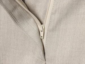 Macro view of high-quality zipper on beige twill trousers with detailed stitching
