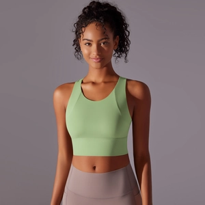 Detailed view of light green sports bra with wide straps and smooth stretch fabric