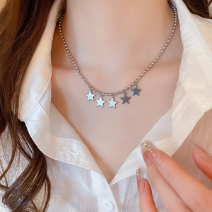 Silver multi-star ball chain necklace shown on model wearing white shirt