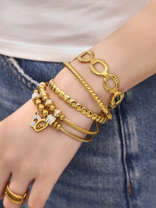 Détail d'un ensemble de bracelets en acier doré avec pendentif cœur Love et zircons fins