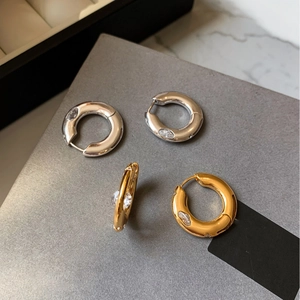 Gold and silver plated zircon hoop earrings with crystal inlay on a neutral background