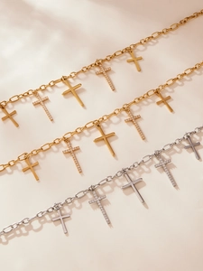 Détail de pendentifs croix en or et argent avec zircons brillants sur des chaînes