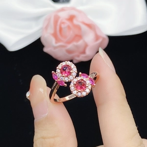 Luxurious rose gold ring with pink tourmaline and pavé diamonds shown on a finger