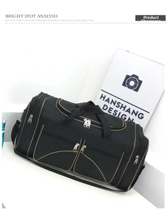 Detail of black nylon travel bag with multi-pockets, tan piping, and adjustable shoulder strap