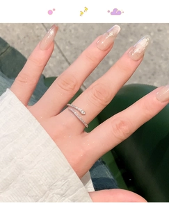 Close-up of a zircon-encrusted snake ring in silver finish worn on the index finger