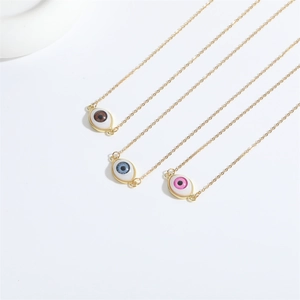 Detailansicht der Evil Eye Anhänger in Braun, Blau und Rosa mit goldenen Gliederketten