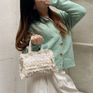 Détail du sac cabas en toile florale avec bordures en dentelle et étiquette Sorakka
