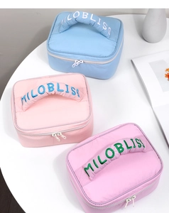 Close-up of quilted macaron cosmetic bags with MILOBLISS embroidery in three soft colors
