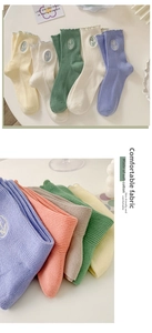 Detailed macro view of pastel cotton socks featuring delicate tulip embroidery and lace edges