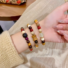 Detailed view of elastic beaded bracelets featuring natural wood beads and colorful accents