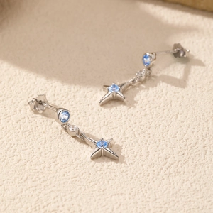 Boucles d'oreilles étoile en argent 925 avec pierres bleues sur fond texturé
