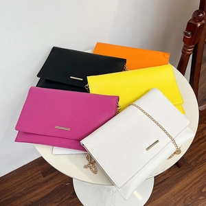 Minimalist envelope crossbody bags in multiple colors with gold chain straps and metal trim