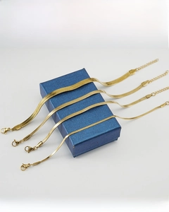 Detailed view of four golden stainless steel snake chains with lobster clasps and extenders