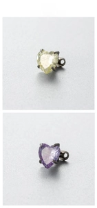 Detailed macro view of 6mm heart-shaped zircon studs in yellow and purple steel settings