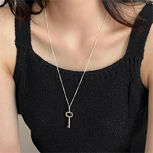 Elegant 925 sterling silver key pendant necklace worn by a model on black clothing