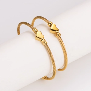 Set of two gold stainless steel open heart bangles with elegant twisted wire textures