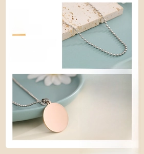 Detailed view of mirror-polished rose gold round pendant with ball chain on textured base