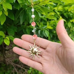 Detail of bohemian sun crystal car pendant with pink beads and faux pearls