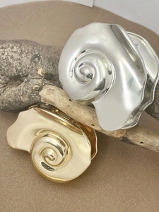 Artistic gold and silver conch shell hair clips on a natural wood branch