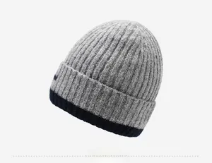 Detail of winter knitted beanie with blue ribbed cuff and grey textured finish