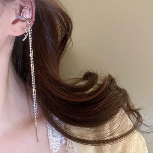Side view of long silver tassel earrings with sparkling rhinestones worn on ear