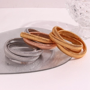 Detailed view of triple-layered flexible snake chain bracelets in gold, silver, and rose gold
