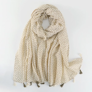 Detail of floral linen shawl with delicate beige and green fringe on a white background
