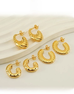 Three pairs of gold titanium steel hoop earrings with threaded and honeycomb textures