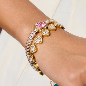 Détails de bracelets dorés avec cristaux roses rectangulaires et cœurs transparents