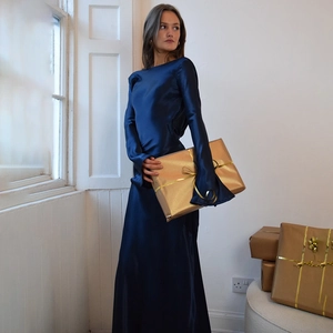 Detail of dark blue satin floor-length evening dress with long sleeves and elegant finish