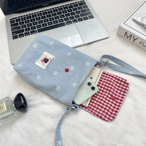 Detail van lichtblauwe denim sterrentas met rode drukknoop en kattenpatch