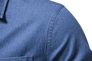Detail view of deep blue denim shirt showing premium stitching and fabric texture
