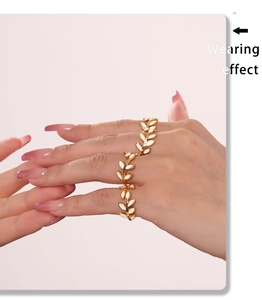 Wearing effect of a 18k gold-plated leaf ring with white enamel detailing on finger