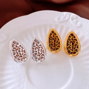 Vintage 24k gold plated leaf drop earrings with leopard print inlay on white ceramic tray