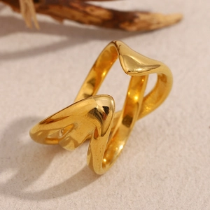 Detail of multi-layer 18K gold-plated wavy stainless steel ring on a textured base