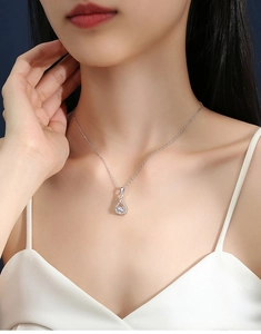 Elegant model wearing a S925 silver water drop pendant with a round moissanite center stone