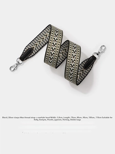 Close-up of black and beige wavy woven bag strap with silver metal swivel hooks